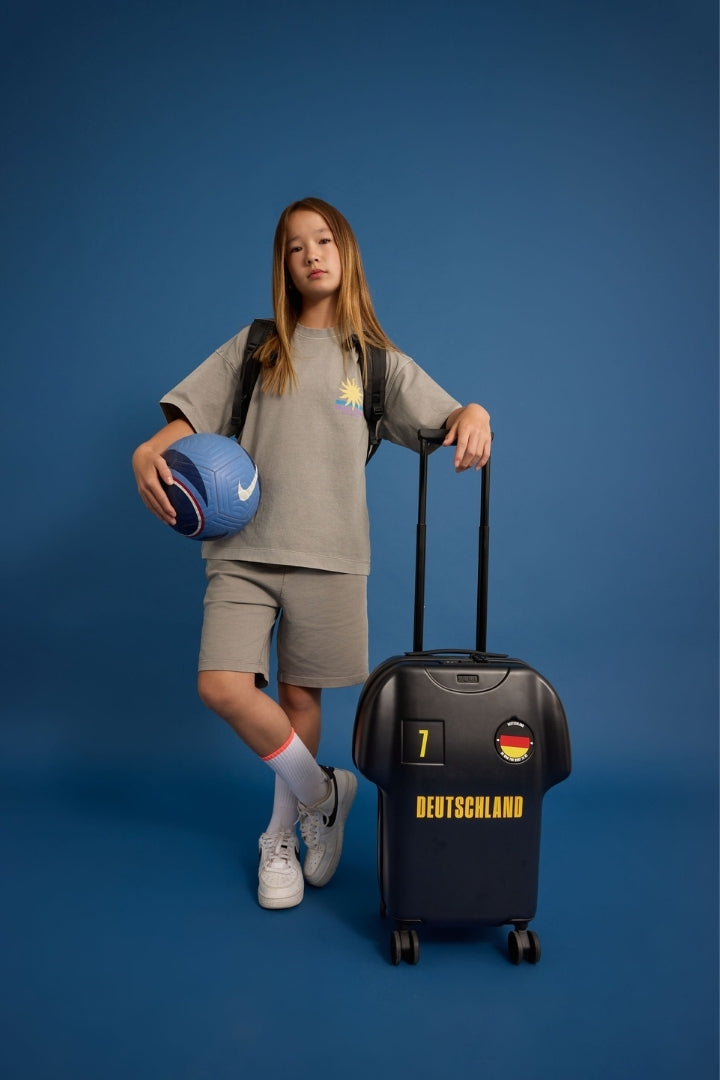 Person with a suitcase and sports ball on a blue background