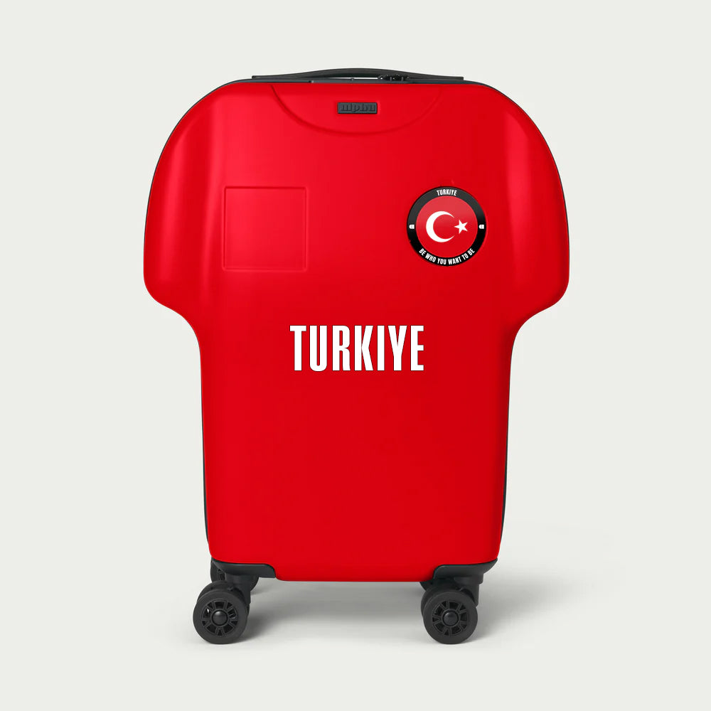 Red suitcase with 'TURKIYE' and Turkish flag design on a light gray background
