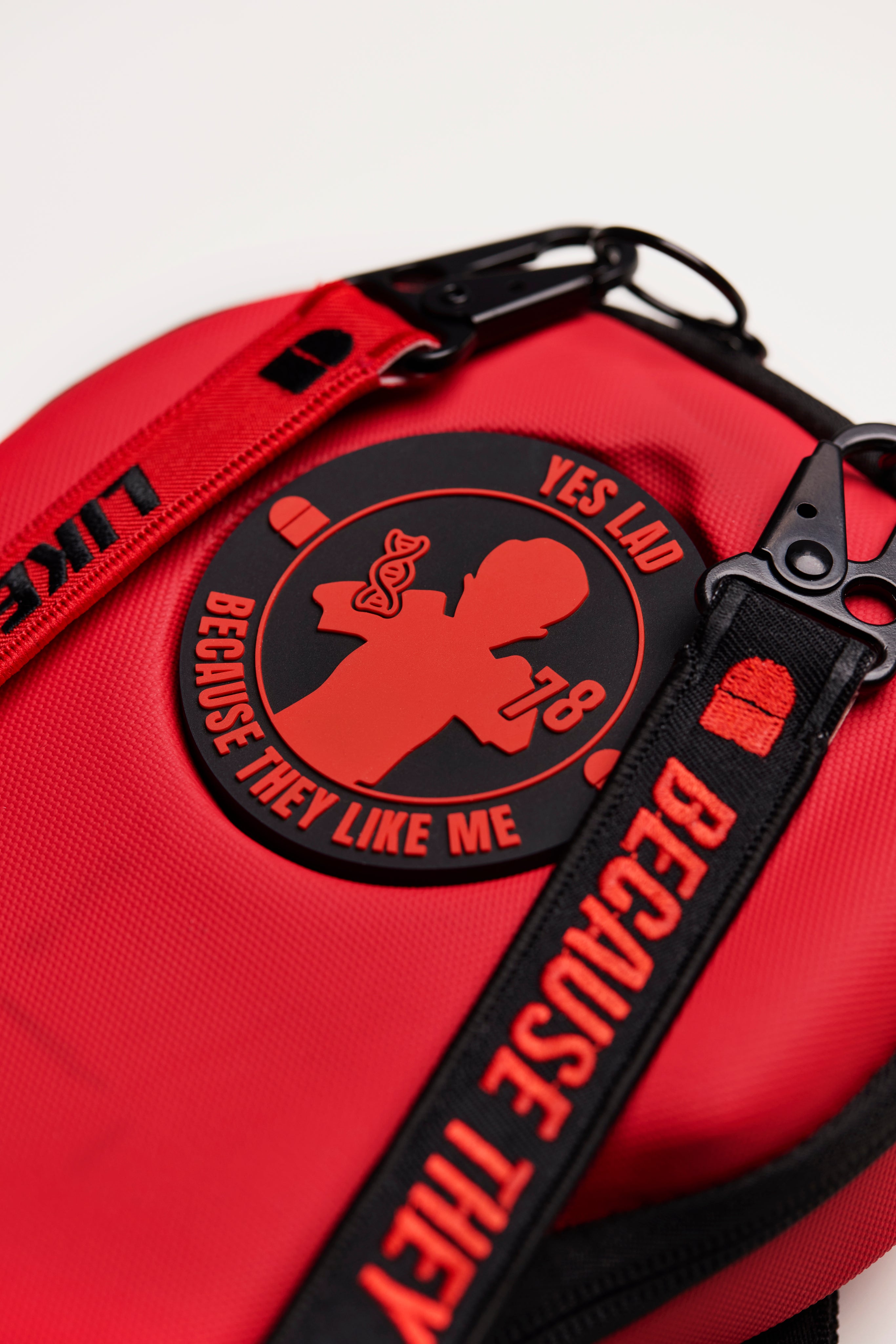 Red bag with a black patch and strap on a white background