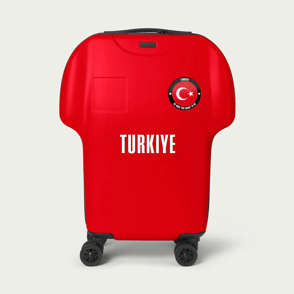 Red shirt-shaped cabin luggage with 'TURKIYE' and Turkish flag design on a light gray background