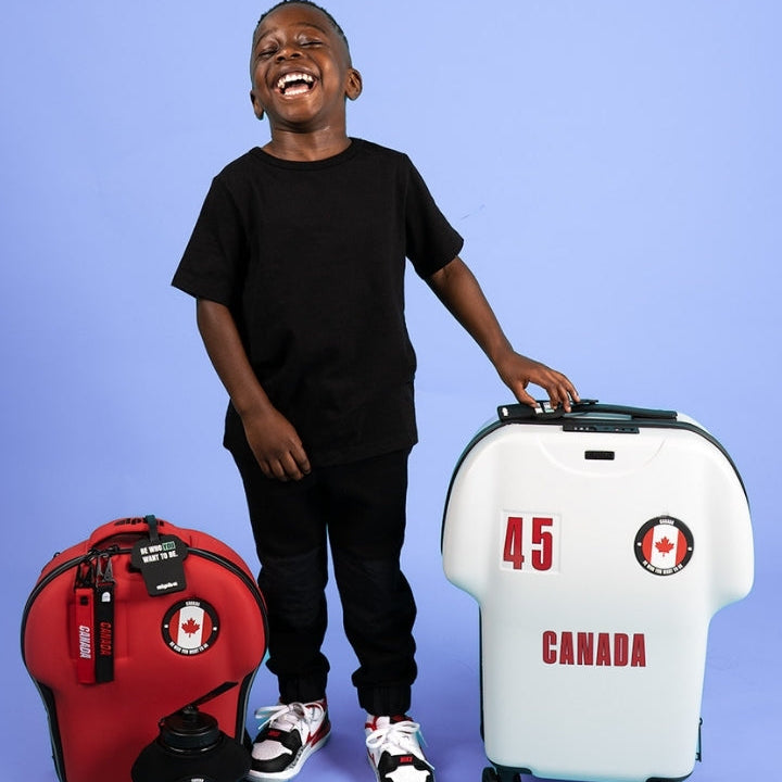 Person standing with a red backpack and white suitcase labeled 'Canada' on a purple background