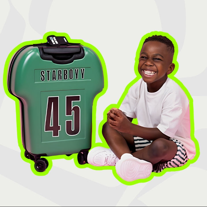 Child sitting next to a green suitcase with 'STARBOY' branding on a white background