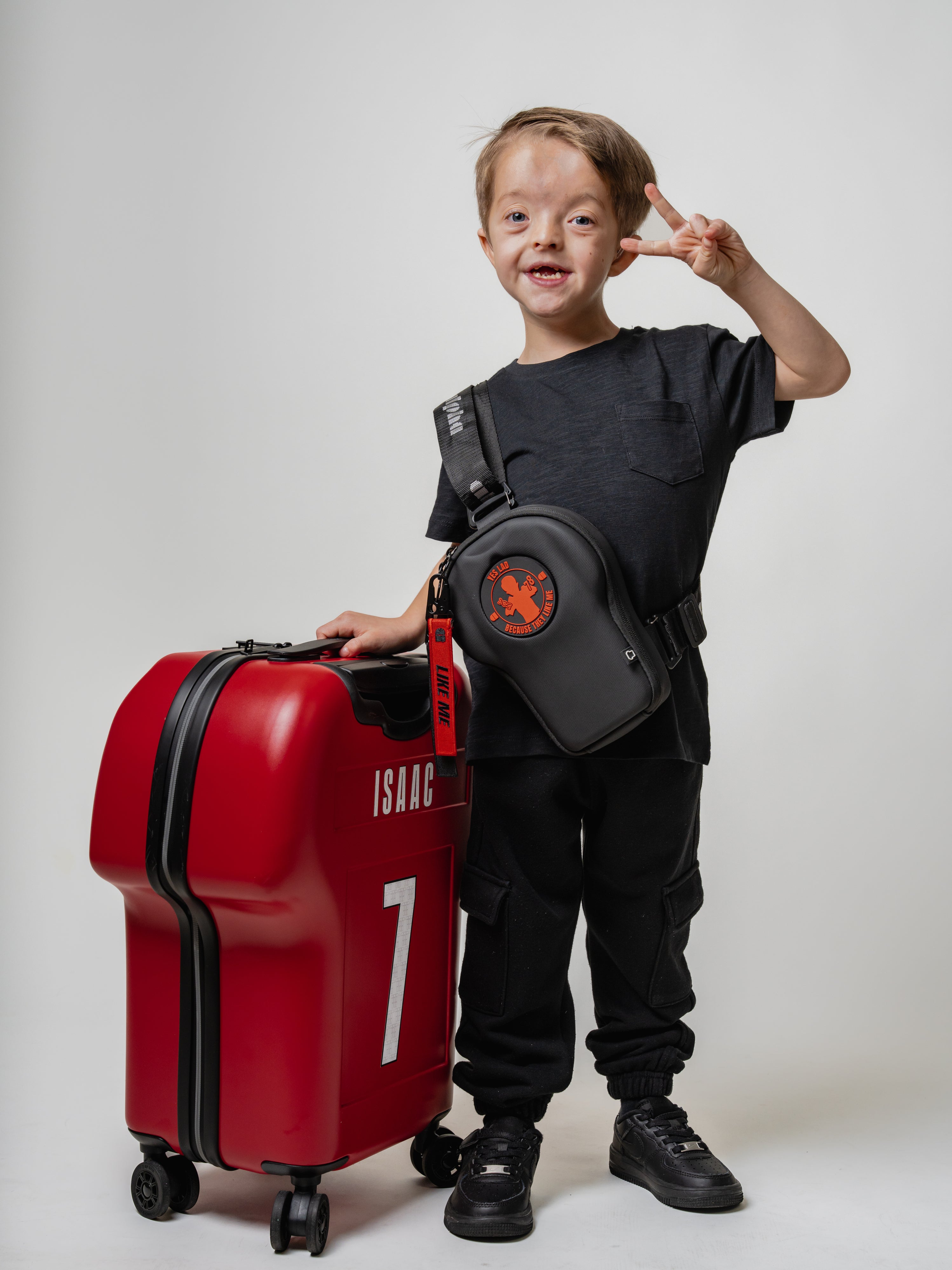 Child with a red suitcase and black bag on a white background