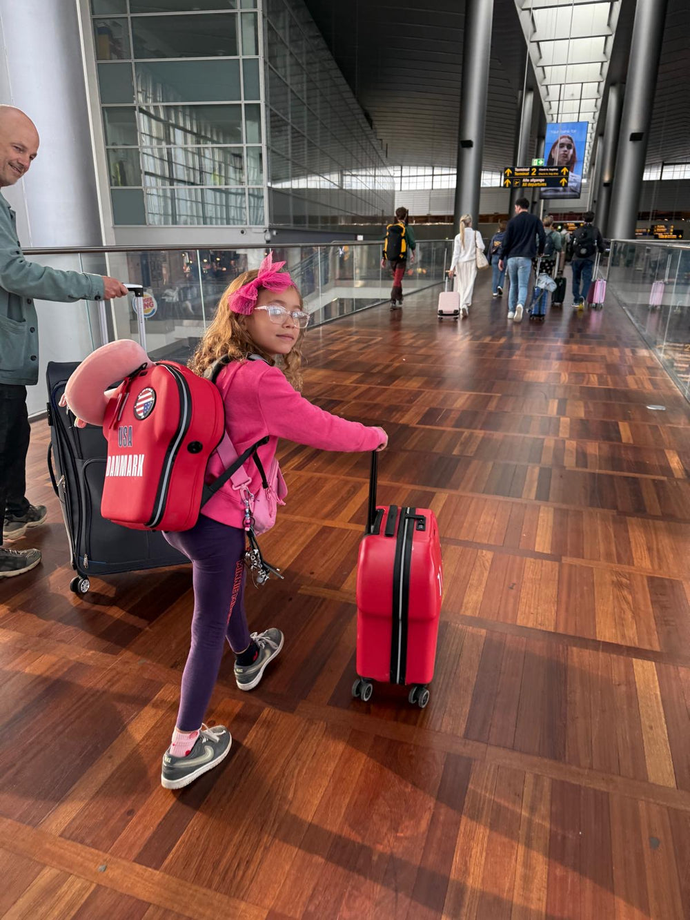 kid travelling with shirt-shaped customised cabin luggage and large backpack