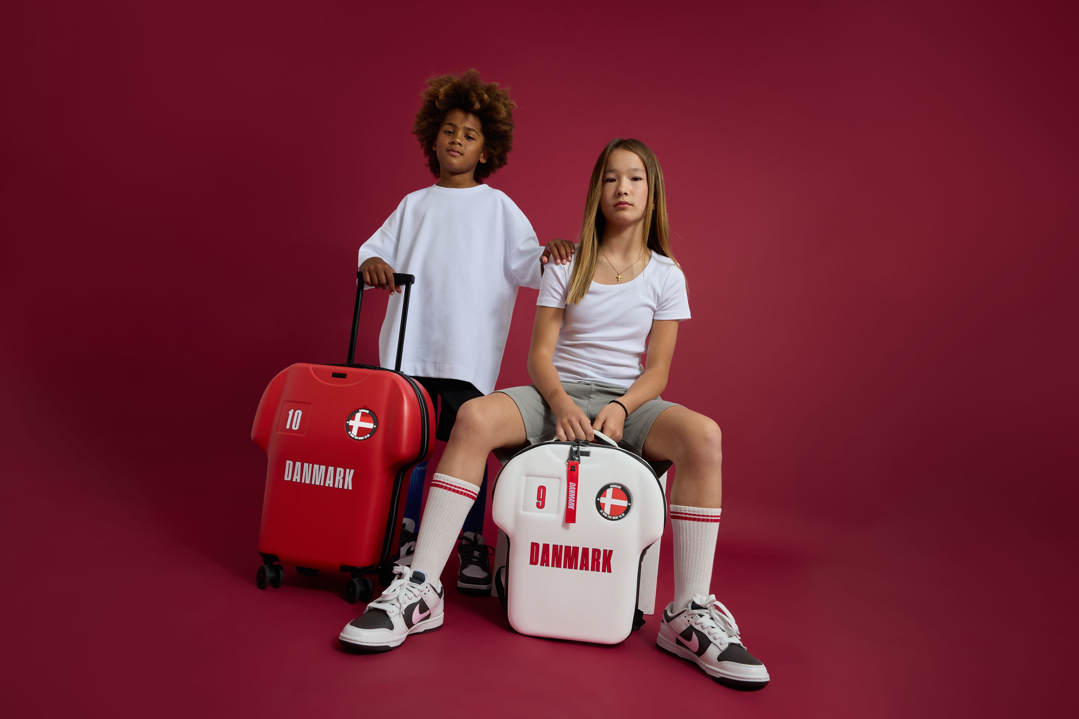to børn til fotoshoot hvor de fremviser alpha trøjeformet rygsæk og kabinekuffert