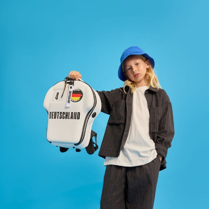 Person holding a white backpack with 'Deutschland' text on a blue background