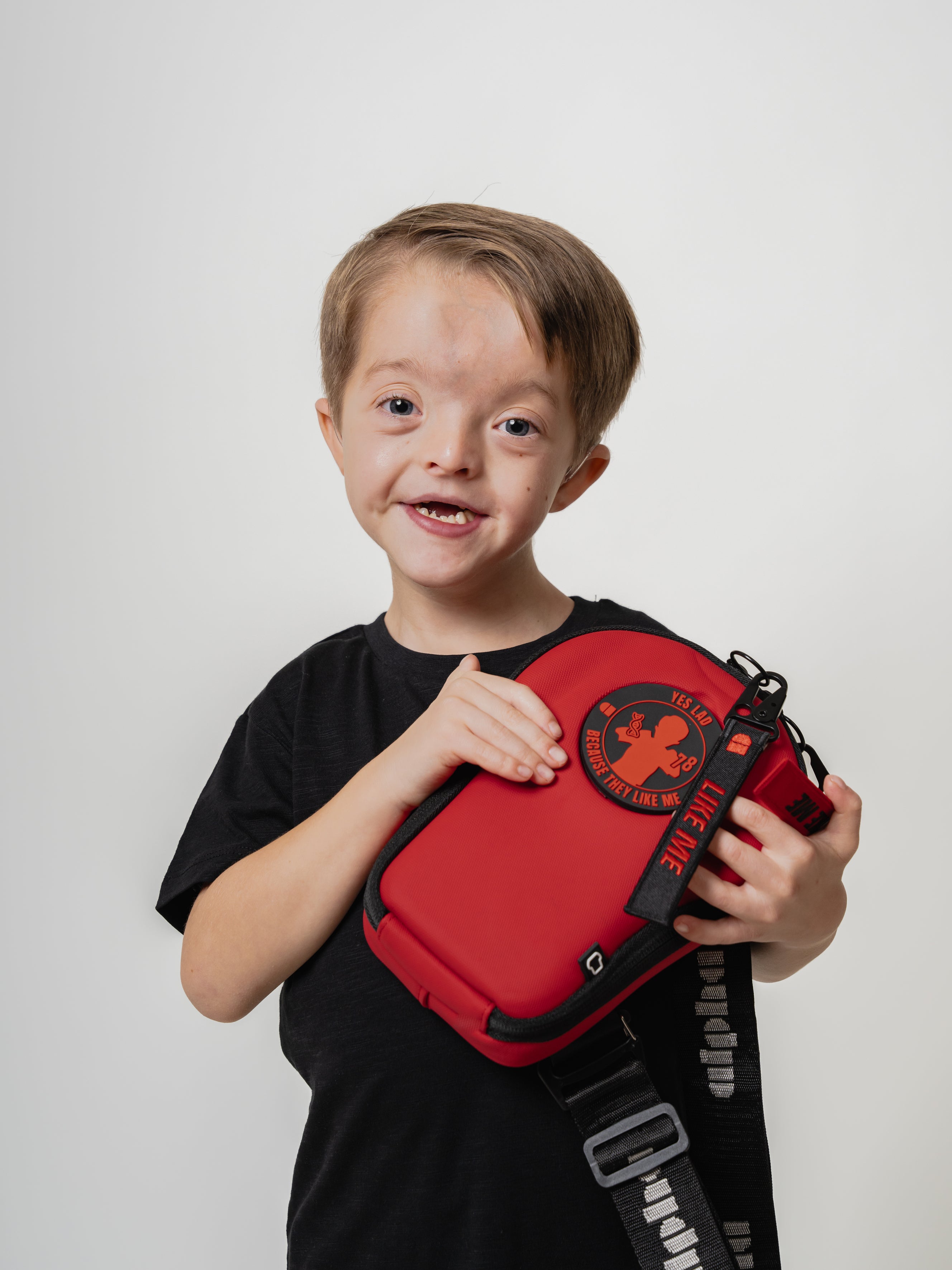 Child holding a red bag with a logo on a white background