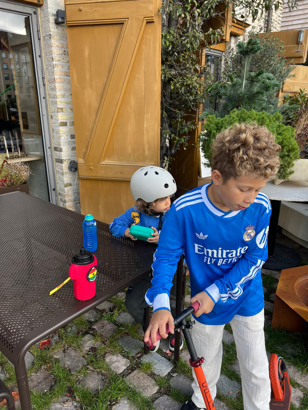 red bottle with sleeve shaped as a shirt on trip with two ghana boys